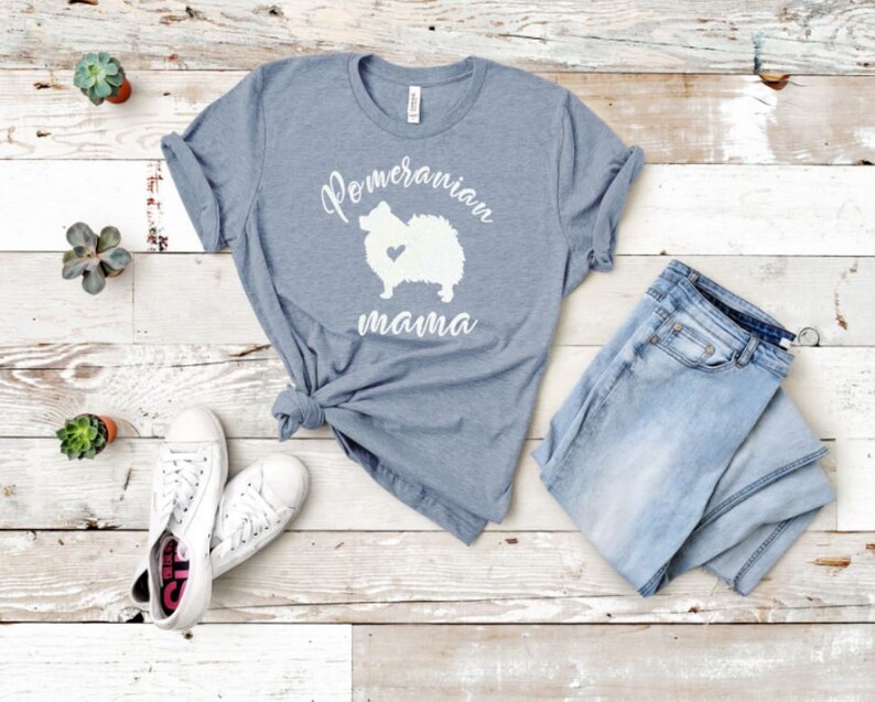 May include: A heather grey t-shirt with a white silhouette of a Pomeranian dog and the text "Pomeranian mama".