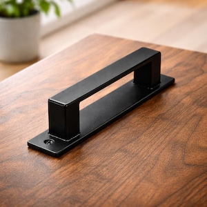 May include: A set of three ceramic mugs with a speckled, matte finish. The mugs are in shades of cream, light gray, and dark gray. Each mug has a simple, minimalist design and a rounded handle.