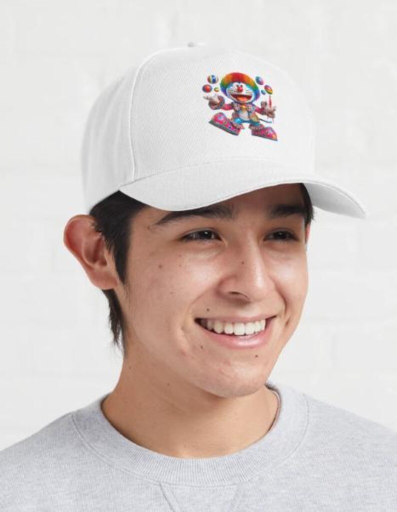 May include: White baseball cap featuring a colorful cartoon character juggling balls. The character has a rainbow-colored hat and is wearing a red and blue outfit. The cap is a classic baseball style with a curved brim.
