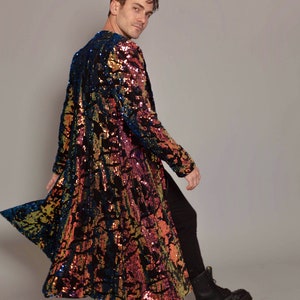 May include: A long, sequined coat with a black base and iridescent blue, pink, and gold sequins. The coat has a loose fit and a long, flowing silhouette.