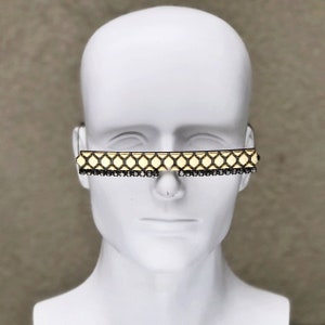 May include: Gold-toned sunglasses with a geometric pattern and black rhinestone accents.