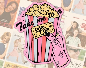 以下が含まれることがあります： 「Take me to a Rom Com」の文字が入ったピンク色のポップコーンバケツのステッカー。バラのタトゥーが入った手が映画のチケットを持っています。背景はロマンチックコメディ映画のポスターのコラージュです。
