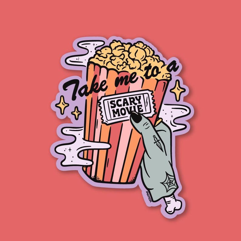 May include: A sticker featuring a cartoon image of a popcorn container with the text "Take me to a Scary Movie." A zombie hand holds a movie ticket. The design includes stars and smoke-like shapes, all set against a red background.