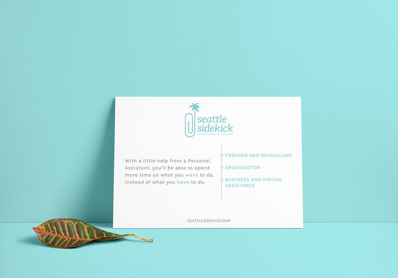 May include: A white card with the text "seattle sidekick" and a stylized paperclip with a palm tree on top. The card lists services offered: errands and scheduling, organization, and business and virtual assistance. The website address "seattlesidekick.com" is at the bottom of the card.