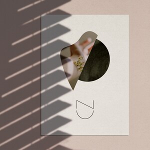 May include: A white card with a black circle and a white abstract shape cut out of it. The cut out shape reveals a floral image. The text "CZ" is printed in black at the bottom of the card.