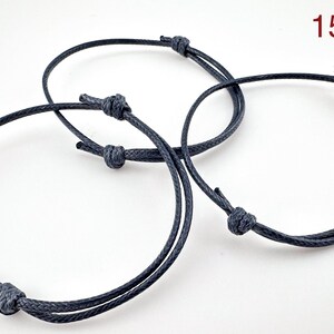 May include: Three adjustable navy blue cord bracelets with knotted closures. The bracelets are circular and appear to be made of a durable, woven material. The number "15" is visible in the upper right corner.