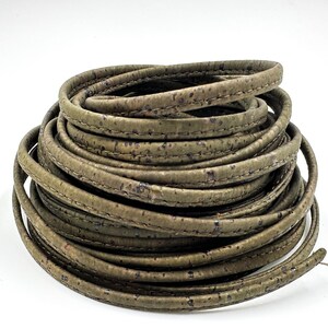 May include: A roll of green cork leather cord with a stitched edge. The cord is approximately 5mm wide.