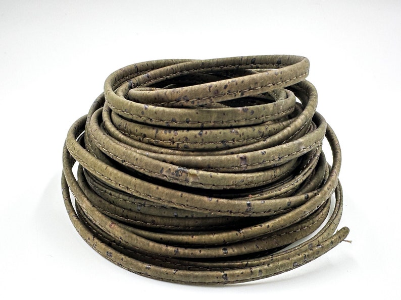 May include: A roll of green cork leather cord with a stitched edge. The cord is approximately 5mm wide.