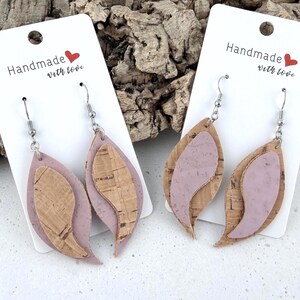 Pode incluir: Dois pares de brincos em forma de gota sobrepostos em cartões brancos com o texto Handmade with love. Cada brinco apresenta uma base de couro sintético malva e uma camada de cortiça natural, suspensos por ganchos de metal prateado.