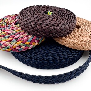 Puede incluir: Cuatro cordones trenzados en diferentes colores y patrones. Los cordones están hechos de cuero y corcho. Los cordones están enrollados y apilados uno encima del otro.