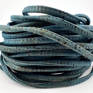 May include: A roll of blue cork cord with white stitching. The cord is made from natural cork and is ideal for crafting and DIY projects.