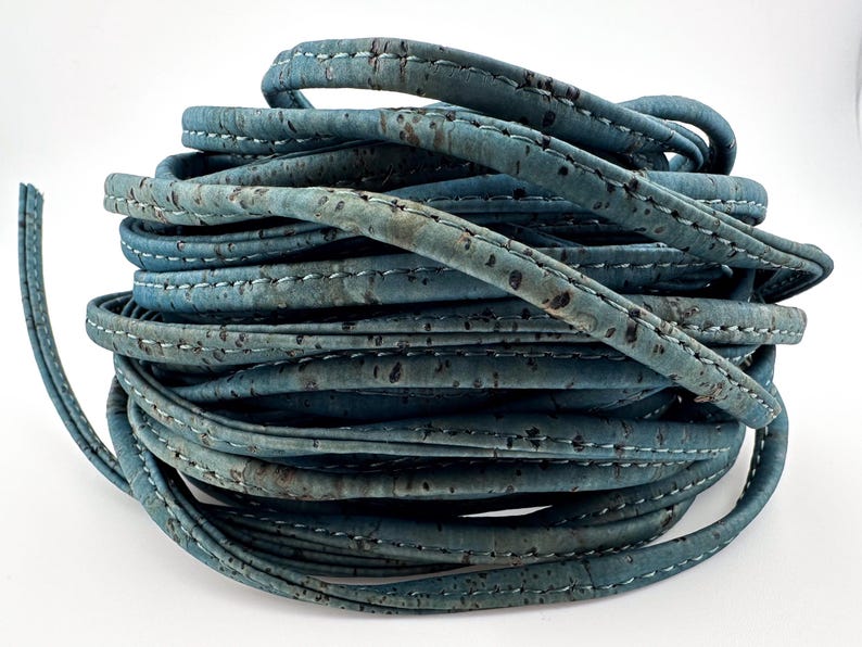 May include: A roll of blue cork cord with white stitching. The cord is made from natural cork and is ideal for crafting and DIY projects.