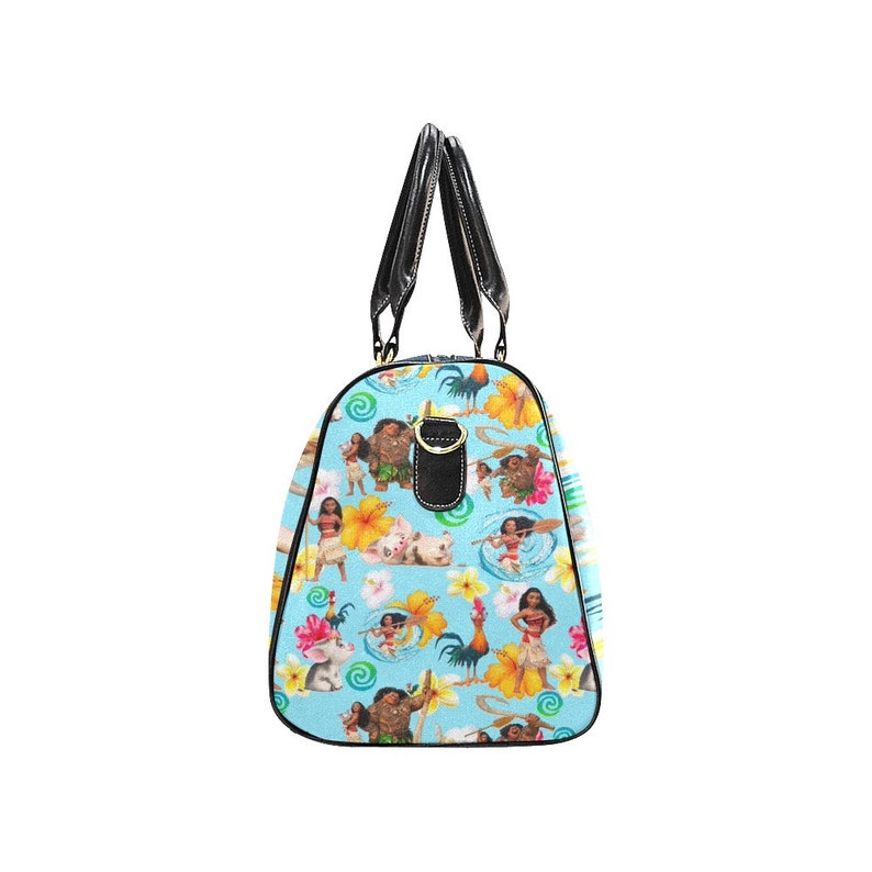 Puede incluir: Una bolsa de viaje azul y blanca con un asa negra y un patr&oacute;n de personajes de la pel&iacute;cula animada Moana. El patr&oacute;n incluye a Moana, Maui, Pua el cerdo, Hei Hei el gallo y otros personajes de la pel&iacute;cula.