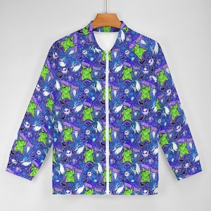 May include: A zip-up bomber jacket with a vibrant pattern featuring green Oogie Boogie characters, bats, and skulls on a blue background. The jacket has a white zipper and is hanging on a wooden hanger.