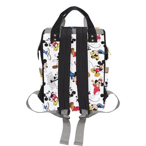 May include: A white canvas backpack with a black zipper and straps. The backpack has a pattern of Mickey Mouse characters in various poses and colors.
