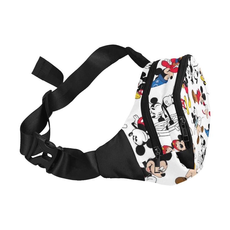 May include: A black and white fanny pack with a white background and a pattern of Mickey Mouse characters in various poses. The pack has two zippered compartments and an adjustable black strap.