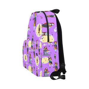 Op de afbeelding: Een paarse rugzak met een herhalend patroon van Sally uit The Nightmare Before Christmas. Het patroon toont Sally in verschillende poses, waaronder zittend op een grafsteen, staand met Jack Skellington en een hart vasthoudend. De rugzak heeft zwarte banden en een zwarte rits.