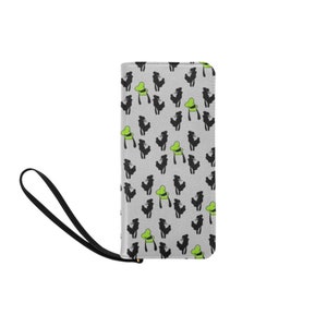 Peut inclure: Un portefeuille noir et vert avec un motif répété d'une silhouette noire d'un personnage portant un chapeau vert. Le portefeuille a une dragonne noire.