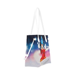 May include: White tote bag with a colourful print of Mickey Mouse as a sorcerer. The print features a blue sky with stars, a cloud, and musical notes.