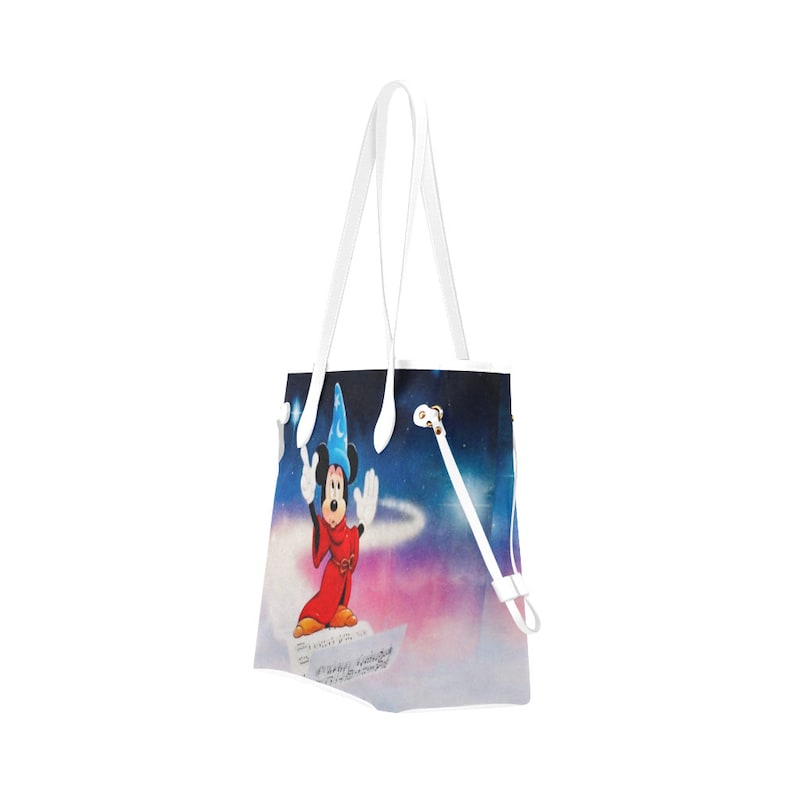 May include: White tote bag featuring a colourful image of Mickey Mouse as a sorcerer. Mickey is wearing a blue hat and red robe. The background is a galaxy with stars and a swirling nebula.