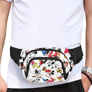 May include: A black fanny pack with a white background featuring a repeating pattern of Mickey Mouse characters in various poses. The pack has two zippered compartments and a black adjustable belt.
