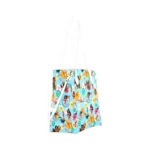 Pu&ograve; includere: Una borsa tote bianca con sfondo blu e un motivo di personaggi del film d'animazione Oceania. I personaggi includono Moana, Maui, Pua il maiale e Hei Hei il gallo. Il motivo include anche fiori, conchiglie e spirali.