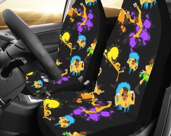 May include: A pair of black car seat covers with a colorful cartoon dog print. The dog is wearing a yellow and blue outfit and is surrounded by colorful paint splatters.