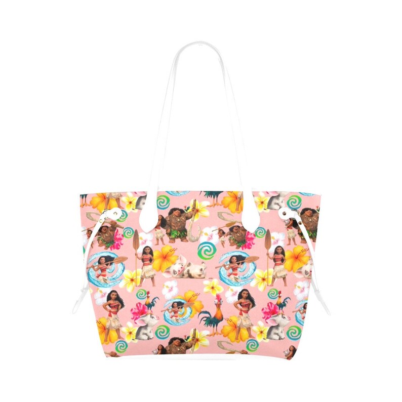 May include: A pink tote bag with a white handle and a repeating pattern of characters from the animated movie Moana. The characters include Moana, Maui, Pua the pig, Hei Hei the rooster, and the demigod Maui.