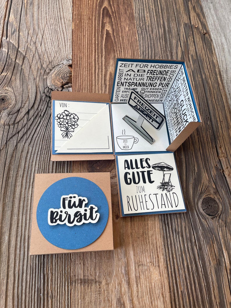 Puede incluir: Una tarjeta marr&oacute;n con un c&iacute;rculo azul y el texto "F&uuml;r Birgit" en blanco. La tarjeta est&aacute; al lado de una tarjeta marr&oacute;n con fondo blanco y el texto "Alles Gute zum Ruhestand" en negro. La tarjeta tambi&eacute;n tiene una ilustraci&oacute;n en blanco y negro de una sombrilla y una silla de playa.