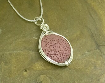 May include: A silver chain necklace with a pendant featuring a round, reddish-brown lava rock wrapped in silver wire.