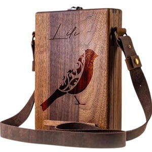 May include: A wooden box with a brown leather strap and a bird design. The box is engraved with the name "Lifi".