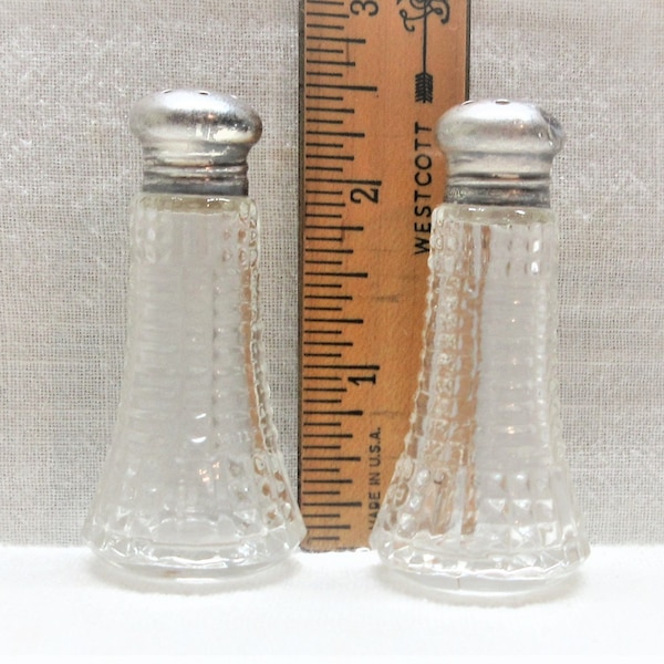 Glass salt & pepper shakers with sterling silver tops. Small set at only 2.5" tall may be considered a personal set. Has dents in the lids