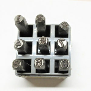 Metal number punch kit set in a plastic holder. Used, some surface rust but numbers look clear. I think it reads 1/4&quot;. Most are CH Hanson