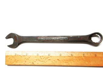 May include: A rusty wrench with a black handle and the word "BARCALO" printed on it. The wrench is 7 inches long and is next to a wooden ruler.