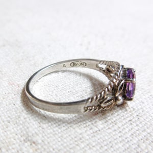 Avon sterling silver ring with an oval amethyst center stone. Marked Avon A and 925. Size 8.75.
