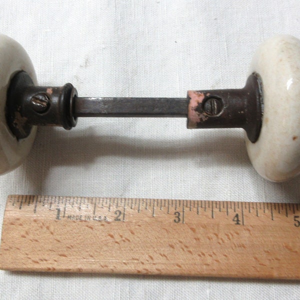 Vintage salvaged white porcelain door knob set. Rusty, one set screw is stuck will need to be worked. Some paint cover and stains.