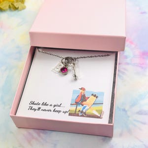 May include: A pink gift box with a silver necklace inside. The necklace has a pink gem, a charm that says "B", and a charm that looks like a skateboard. The box has a white card inside with the text "Skate like a girl... They'll never keep up!"