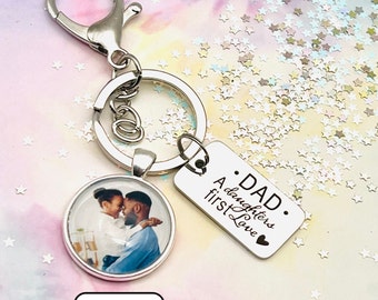 May include: Silver keyring with a round photo charm and a rectangular tag. The tag says "A daughter's first love. Dad".