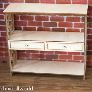 May include: A wooden shelf unit with two drawers and two open shelves. The shelf unit is made of light wood and has a simple, modern design.