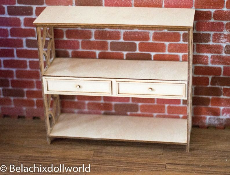 May include: A wooden shelf unit with two drawers and two open shelves. The shelf unit is made of light wood and has a simple, modern design.