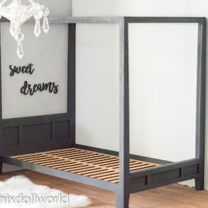 Puede incluir: Una cama con dosel negro con una cabecera y un piecero de madera con listones. La cabecera tiene una pared gris detr&aacute;s con las palabras "sweet dreams" escritas en negro.