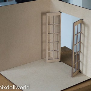 May include: A miniature dollhouse room with brown cardboard walls and a set of double French doors with glass panes.