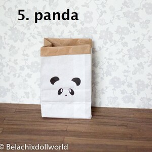 May include: A white paper bag with a brown top and a black panda face design. The bag is sitting on a wooden floor.