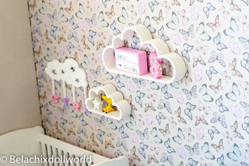 May include: White cloud-shaped shelves with a pink light-up sign that says "Sweet Dreams" and a pink letter "S" on a wall with a butterfly pattern.