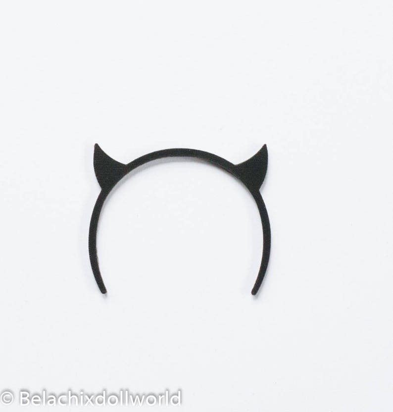 May include: Black devil horn headband. The headband is made of a flexible material and has two pointed horns.