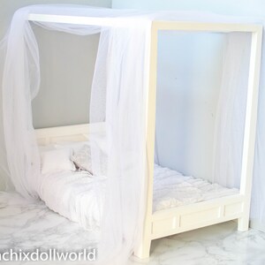 Puede incluir: Cama con dosel blanco con un edred&oacute;n y almohadas blancas. La cama est&aacute; hecha de madera y tiene un marco blanco. El dosel est&aacute; hecho de tela blanca y cuelga del techo.