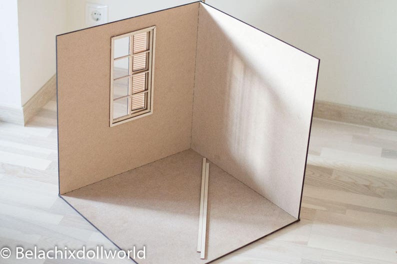 May include: A miniature room made of cardboard with a window and a wooden floor. The room is empty and ready for decorating.