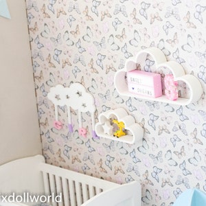May include: White cloud-shaped shelves with a pink sign that reads "Sweet Dreams" and a donut decoration. The shelves are mounted on a wall with a butterfly pattern wallpaper.