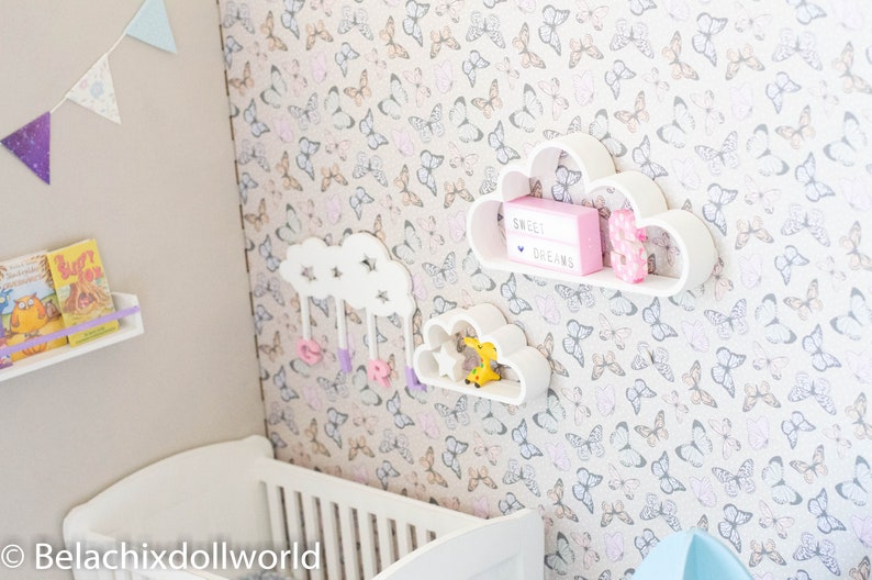 May include: White cloud-shaped shelves with a pink sign that reads "Sweet Dreams" and a donut decoration. The shelves are mounted on a wall with a butterfly pattern wallpaper.