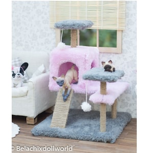 May include: A pink cat tree with a gray platform, a scratching post, and a fluffy pink bed. Two small, hairless cats are playing on the cat tree.